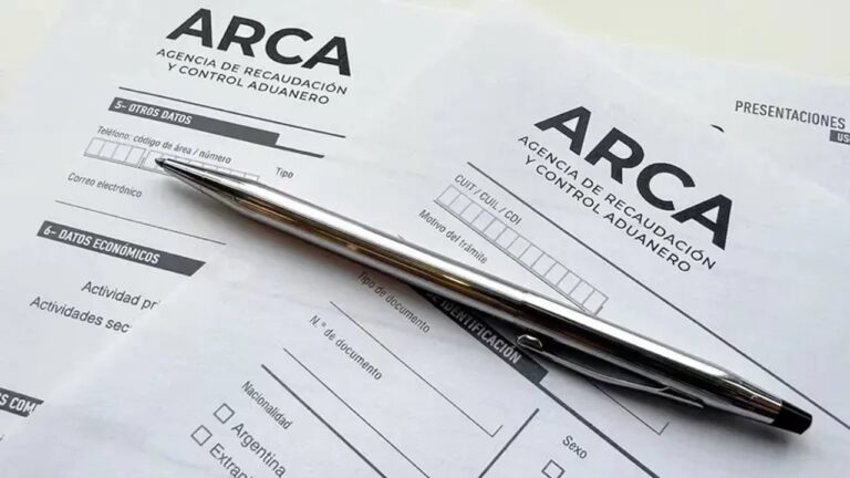 Persona revisando documentos fiscales en escritorio con calculadora y celular