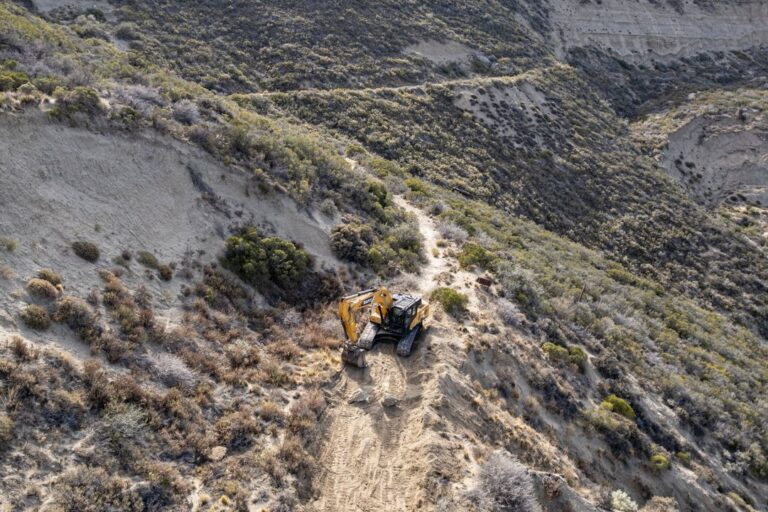 Maquinaria vial trabajando en el reacondicionamiento de un camino en el cerro Hermitte, Comodoro Rivadavia.