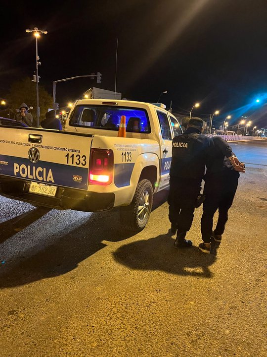 Ilustración de un procedimiento policial nocturno en una calle de Comodoro Rivadavia.