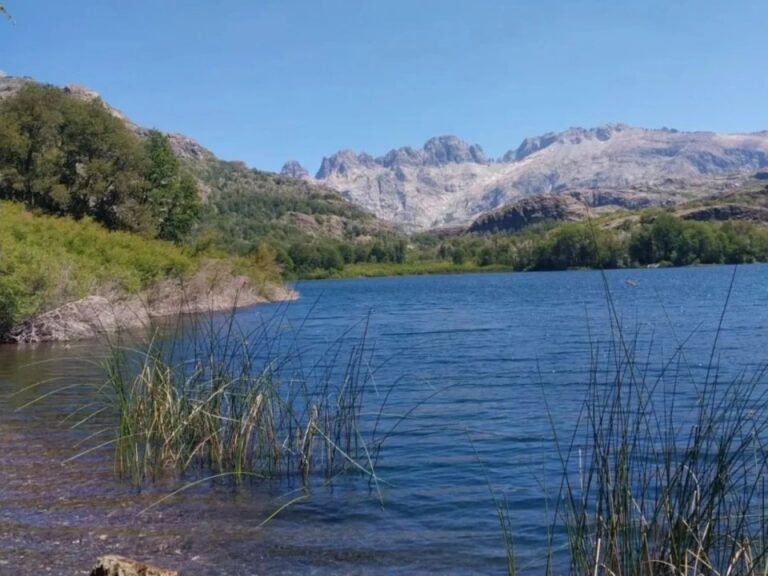 Vista panorámica de la Laguna Chaquira, rodeada de bosque andino patagónico con colores otoñales, en el sistema de Lagunas de Epulafquen, Neuquén.