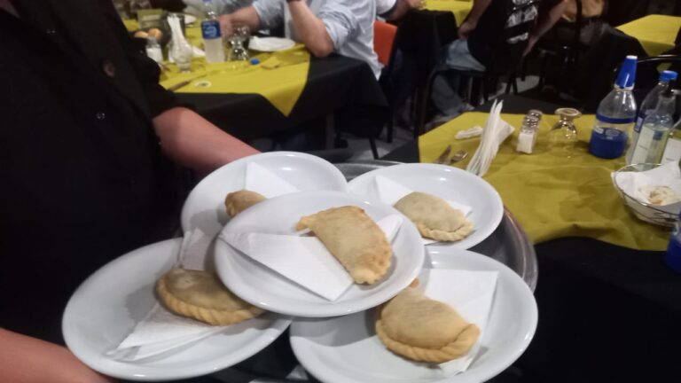 Comensales degustando empanadas y asado de carne de burro en un restaurante de Trelew, Chubut.