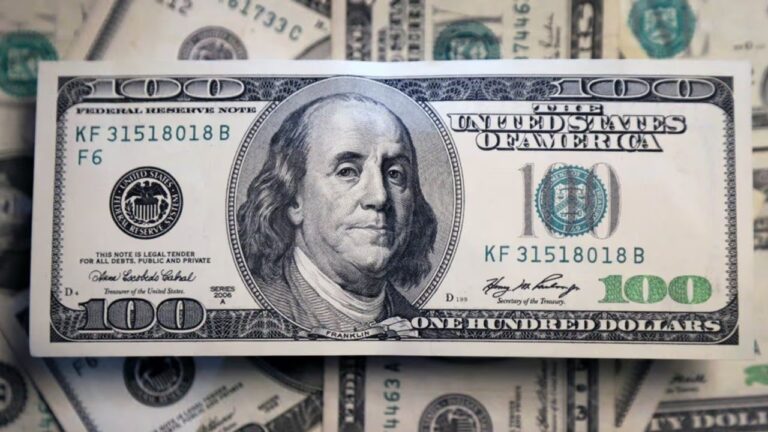 Billetes de dólar estadounidense y de peso argentino sobre una mesa