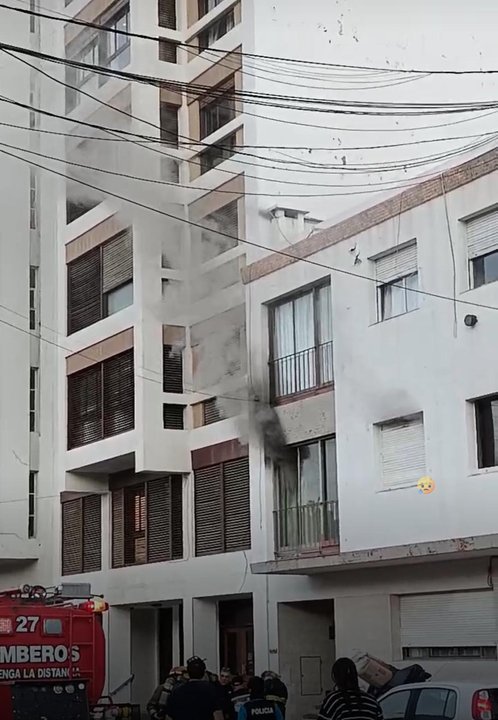 Bomberos trabajando en el incendio de un departamento en Comodoro