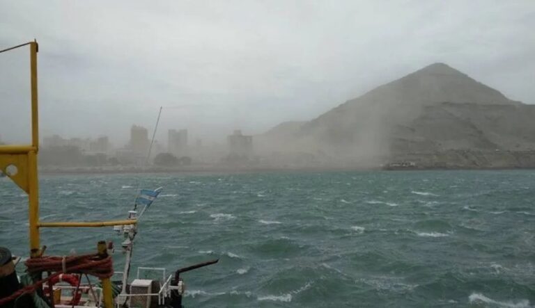 Vista de Comodoro Rivadavia con cielo nublado y banderas movidas por el viento