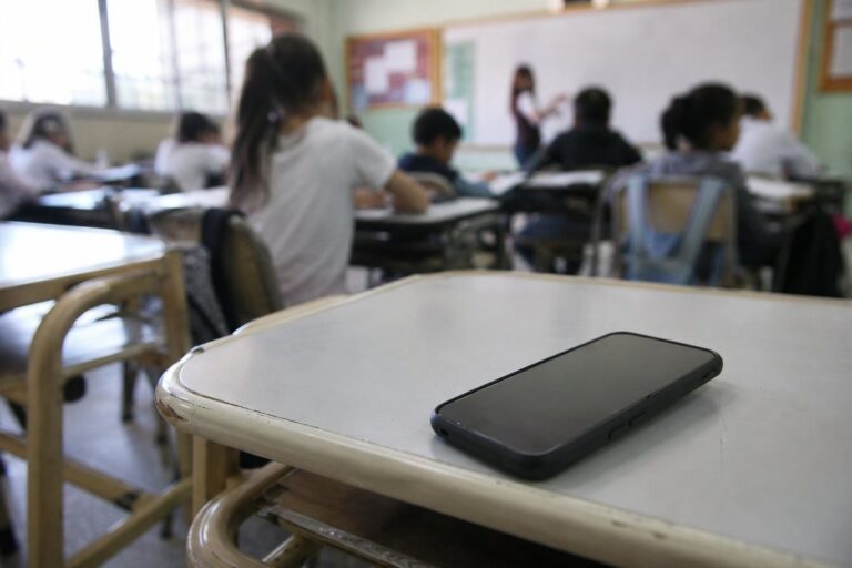 Estudiantes en un aula de Chubut con celulares sobre el escritorio