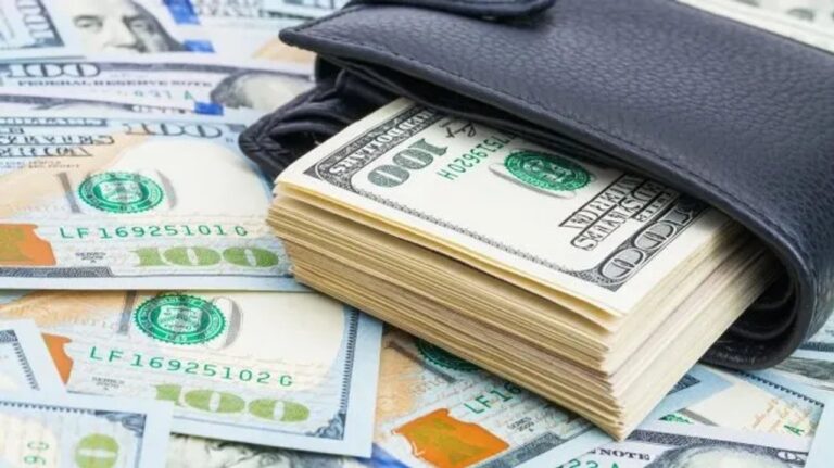 Billetes de dólar estadounidense y pesos argentinos sobre una mesa