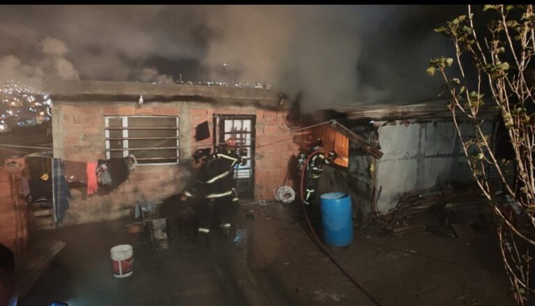 Bomberos trabajando en la vivienda incendiada en el barrio Vepam de Trelew