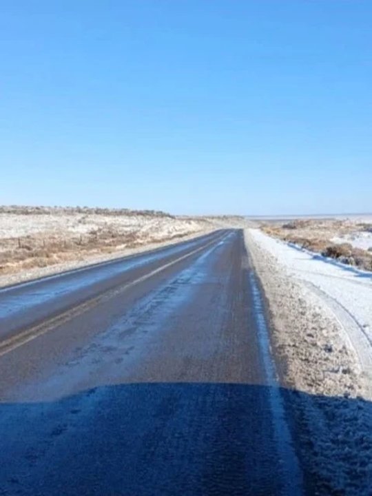Ruta en Chubut con hielo y nieve, auto circulando con precaución
