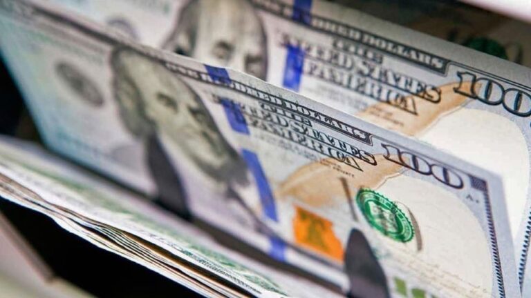 Billetes de dólar estadounidense y pesos argentinos sobre una mesa