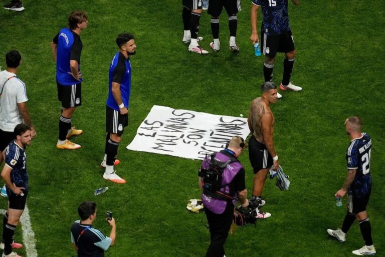 Jugadores argentinos sosteniendo bandera con leyenda Las Malvinas son argentinas