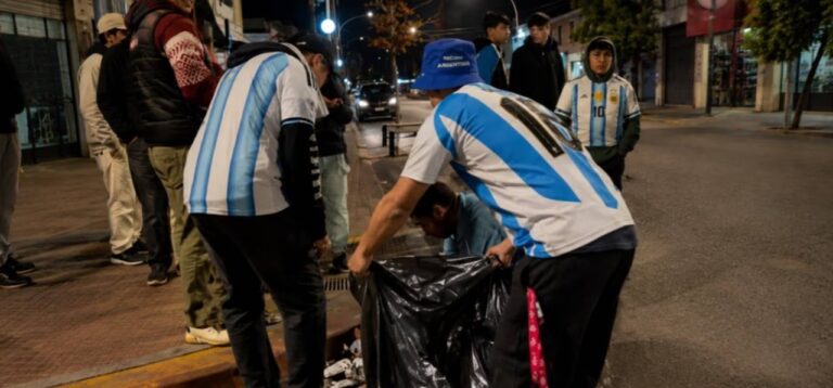 Personas recogiendo residuos en la calle 25 de Mayo de Esquel tras festejos deportivos