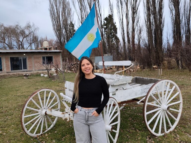 Macarena Goyeneche preparando un asado al aire libre en una chacra de Trelew