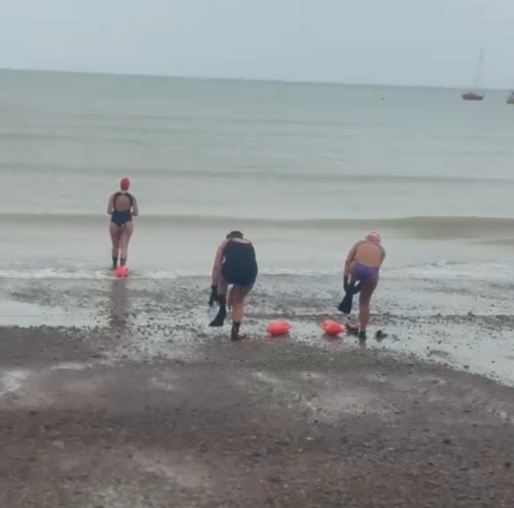 Mujeres saliendo del mar con copos de nieve en el pelo en Comodoro Rivadavia