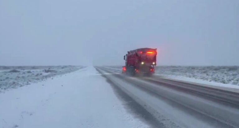 Ruta nevada en Chubut con vehículos circulando y equipos viales trabajando