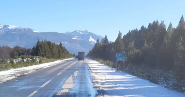 Ruta cordillerana con nieve y cartel de cadenas obligatorias