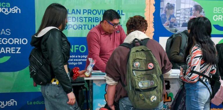 Estudiantes universitarios consultando información sobre becas en Neuquén