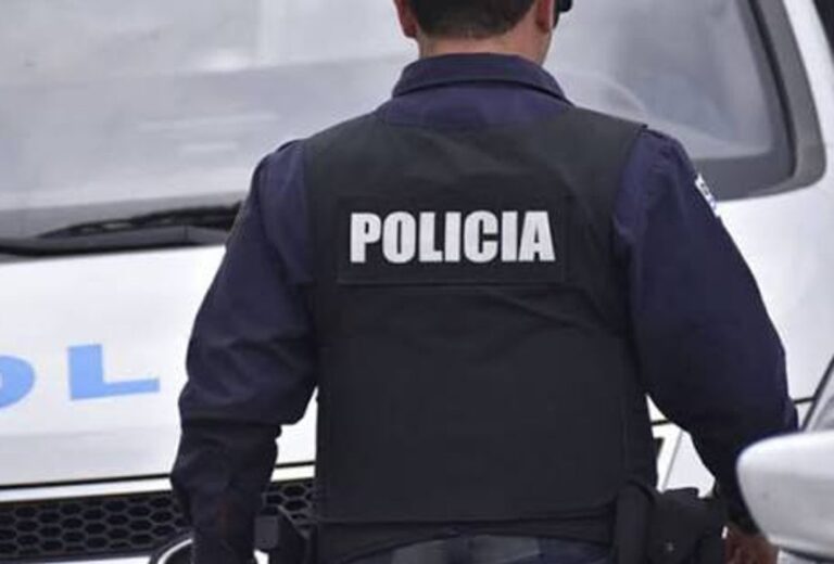 Policía científica en la puerta de una vivienda con daños por disparos
