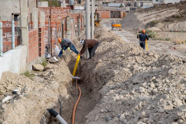 Obreros trabajando en la instalación de cañerías de gas en un barrio de Comodoro Rivadavia