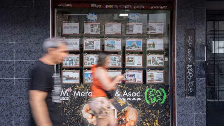 Persona revisando facturas de servicios y alquiler en una mesa